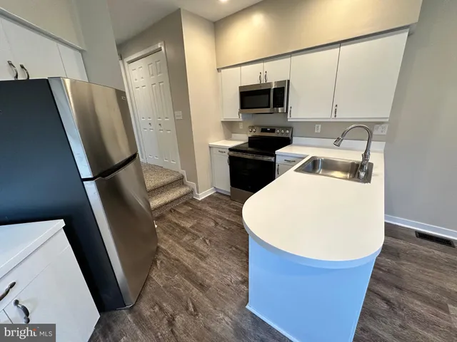 a kitchen with stainless steel appliances a refrigerator stove microwave and sink