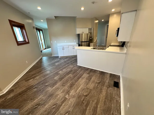 a view of a kitchen with a sink and wooden floor
