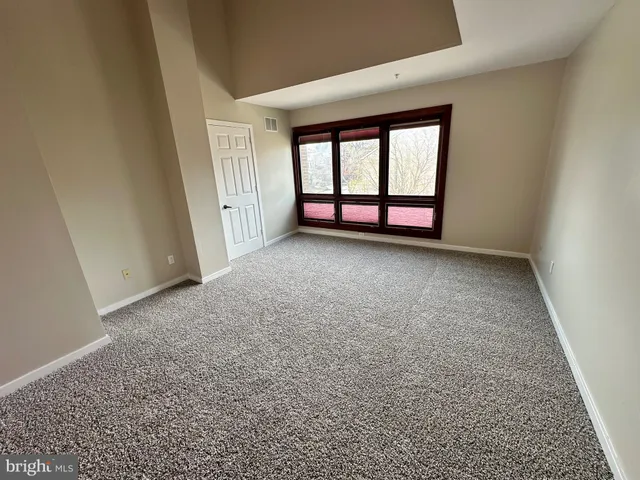 an empty room with windows and closet