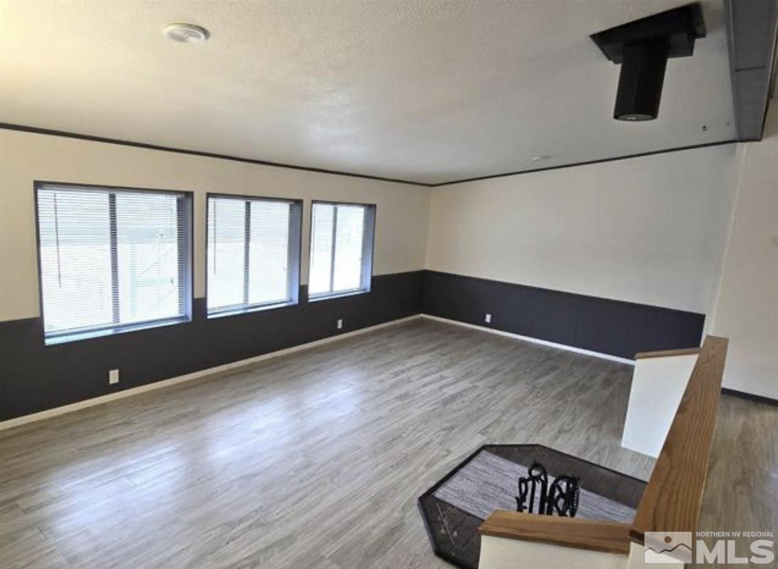 16355 Rhyolite Circle Reno, NV 89521 - Photo 11 of 26 a view of an empty room with wooden floor and a window