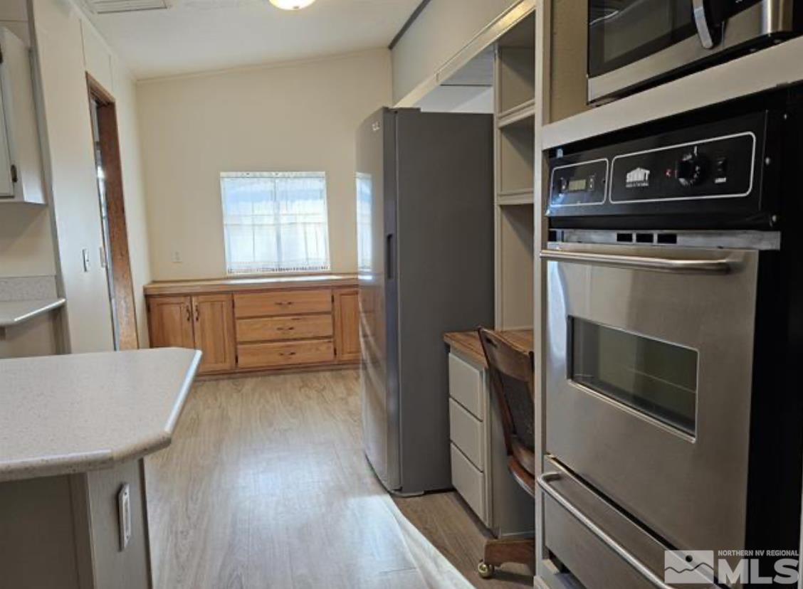 16355 Rhyolite Circle Reno, NV 89521 - Photo 13 of 26 a kitchen with stainless steel appliances a stove a microwave and a refrigerator