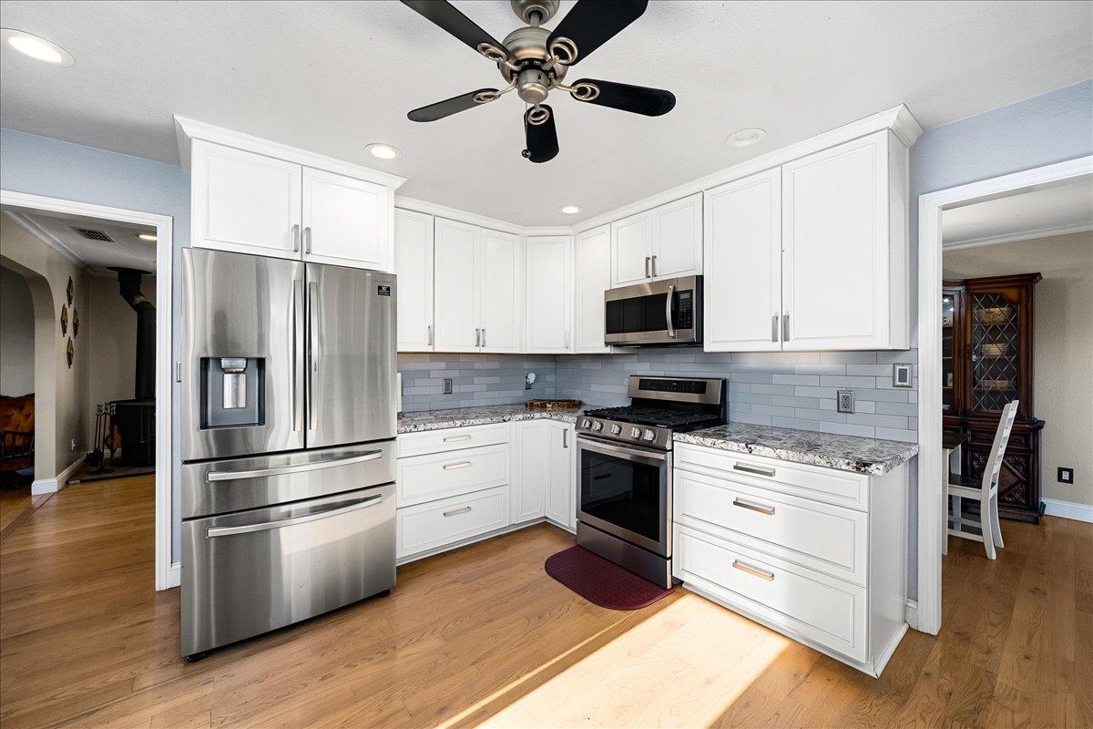4371 Luneman Road Placerville, CA 95667 - Photo 9 of 77 a kitchen with stainless steel appliances a refrigerator stove and white cabinets