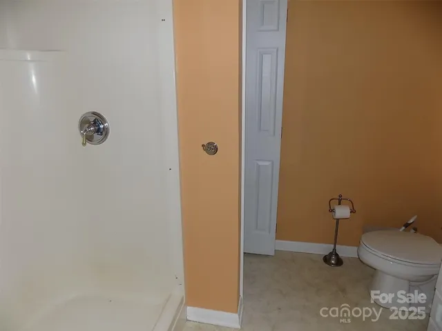 a bathroom with a toilet and a shower