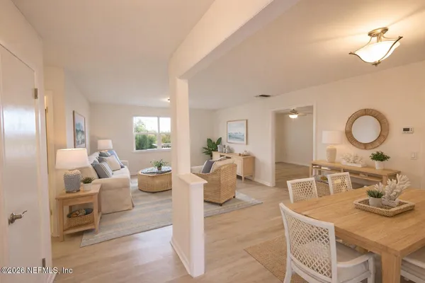 a view of a livingroom with wooden floor and a kitchen space