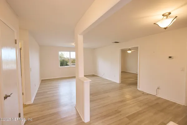a view of a big room with wooden floor and windows