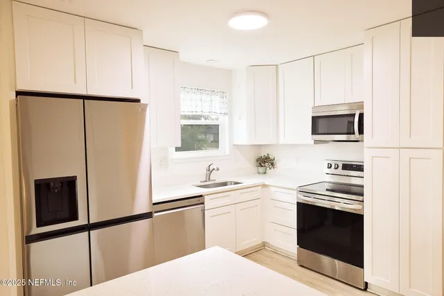 a kitchen with stainless steel appliances a refrigerator sink and microwave