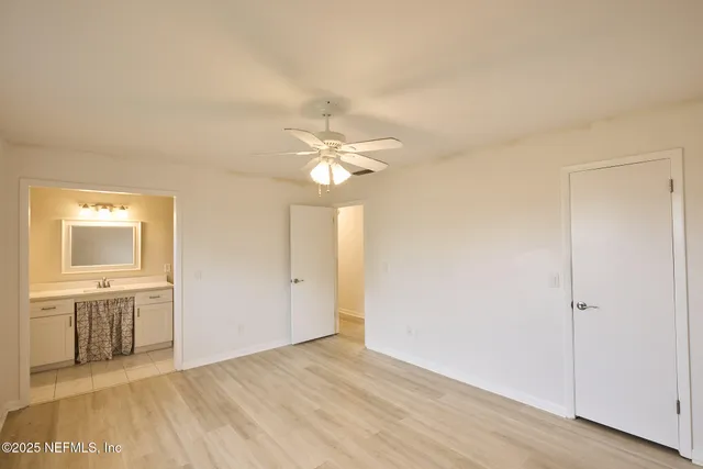a view of a livingroom with a chandelier fan and wooden floor