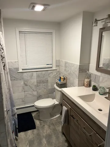 a bathroom with a sink toilet and mirror