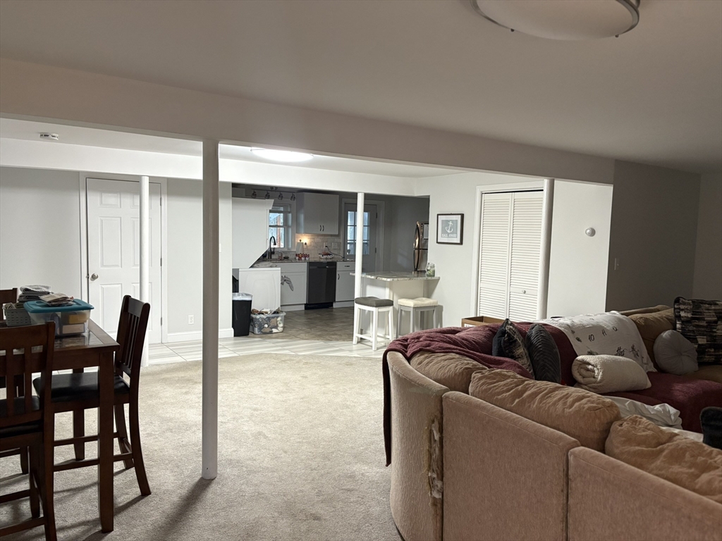 55 Fox Hill Road, Unit 1 Nahant, MA 01908 - Photo 5 of 9 a living room with furniture and a dining table with chair