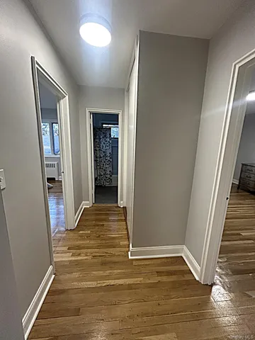 a view of a hallway with wooden floor and staircase