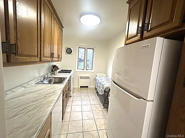 a kitchen with a refrigerator a sink and wooden cabinets