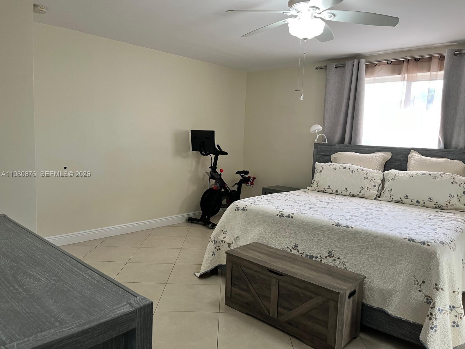 685 West 77th Street Hialeah, FL 33014 - Photo 14 of 35 a bedroom with a bed and a chandelier
