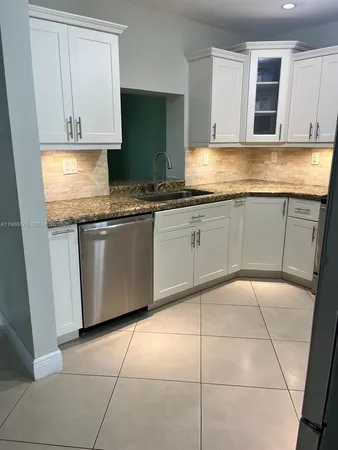 a kitchen with granite countertop a sink and cabinets
