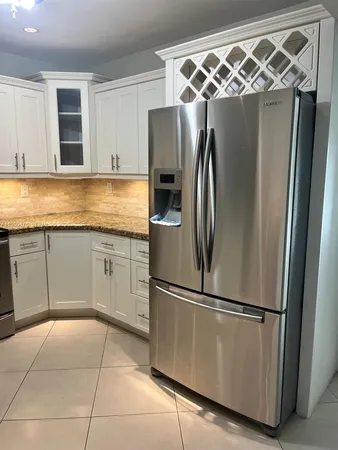 a kitchen with stainless steel appliances granite countertop a refrigerator and a sink