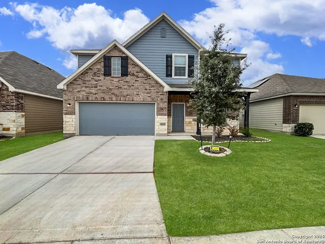 a front view of a house with yard and green space