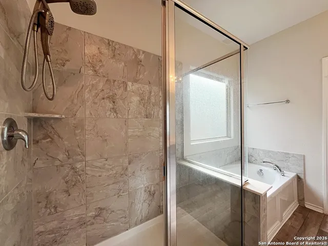a view of an empty room with a ceiling fan and window