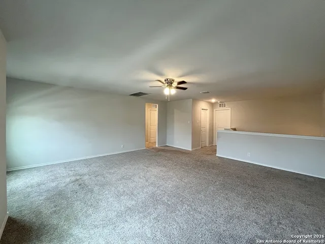 an empty room with windows and fan