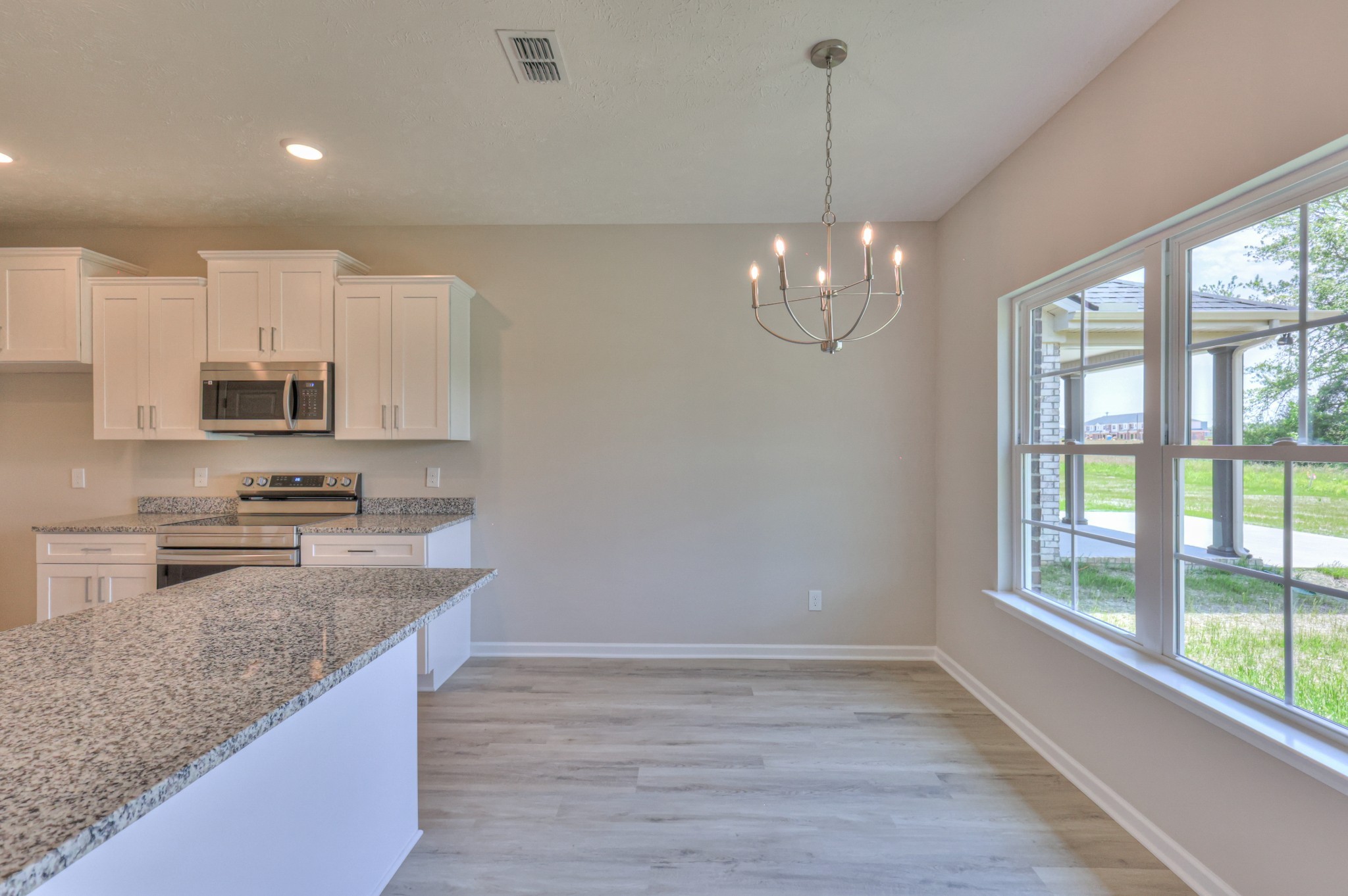 201 North Fork Branch Road Tullahoma, TN 37388 - Photo 14 of 31 a kitchen with kitchen island granite countertop a stove a sink a center island and a window