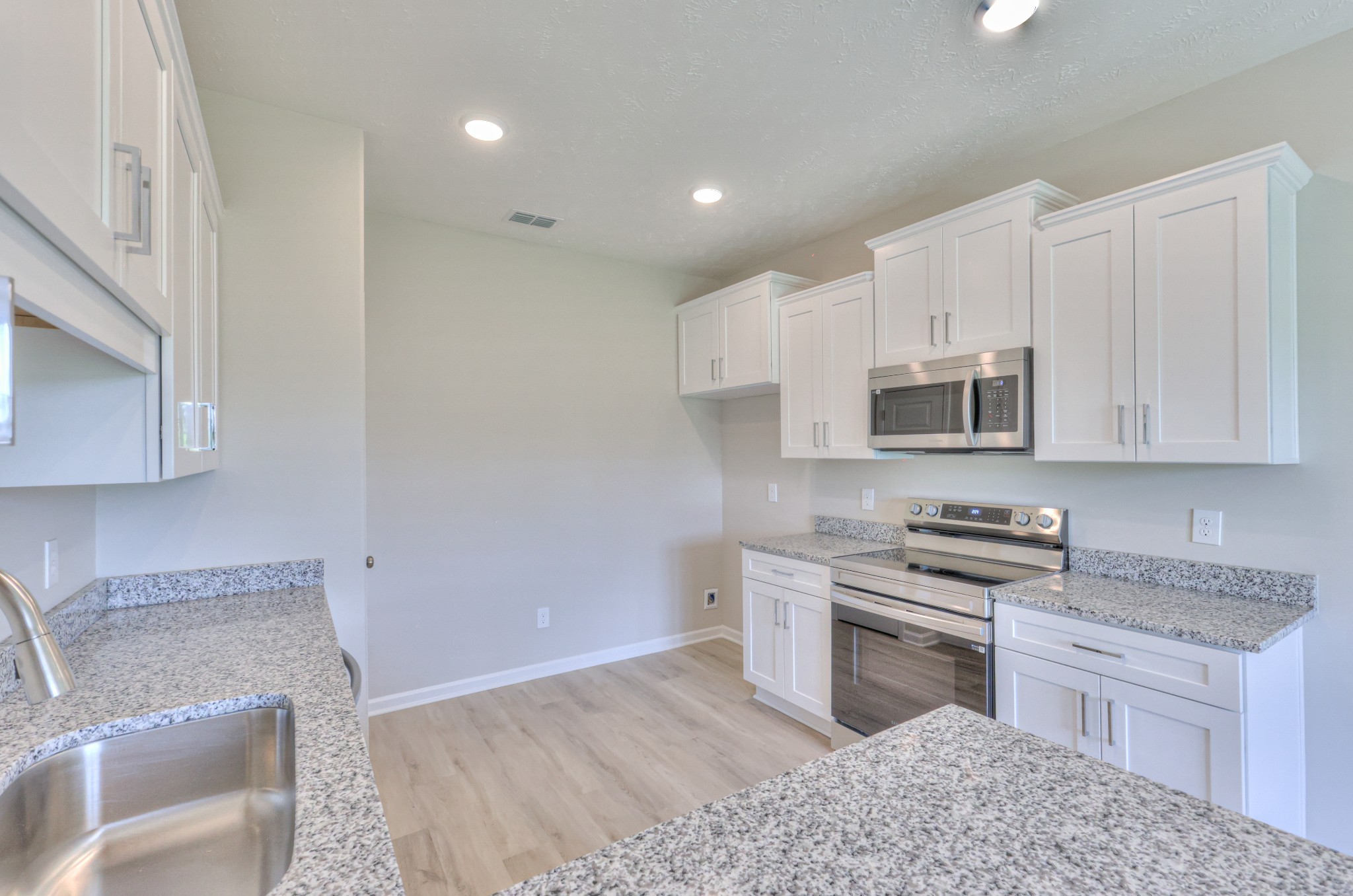 201 North Fork Branch Road Tullahoma, TN 37388 - Photo 18 of 31 a kitchen with stainless steel appliances granite countertop a sink a stove a microwave a counter space and cabinets