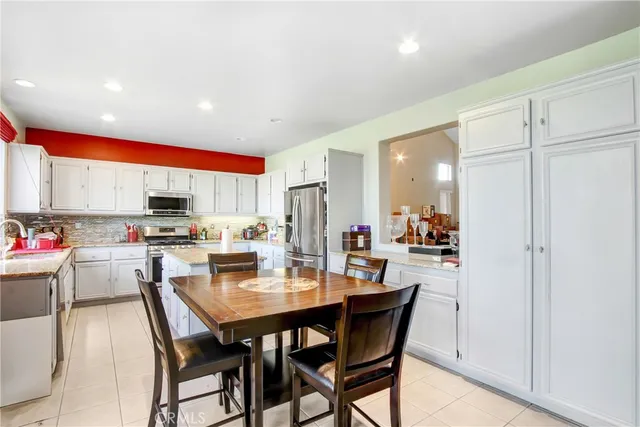 a kitchen with stainless steel appliances a dining table and chairs