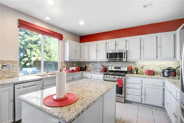 a kitchen with stainless steel appliances granite countertop a sink dishwasher and cabinets with wooden floor