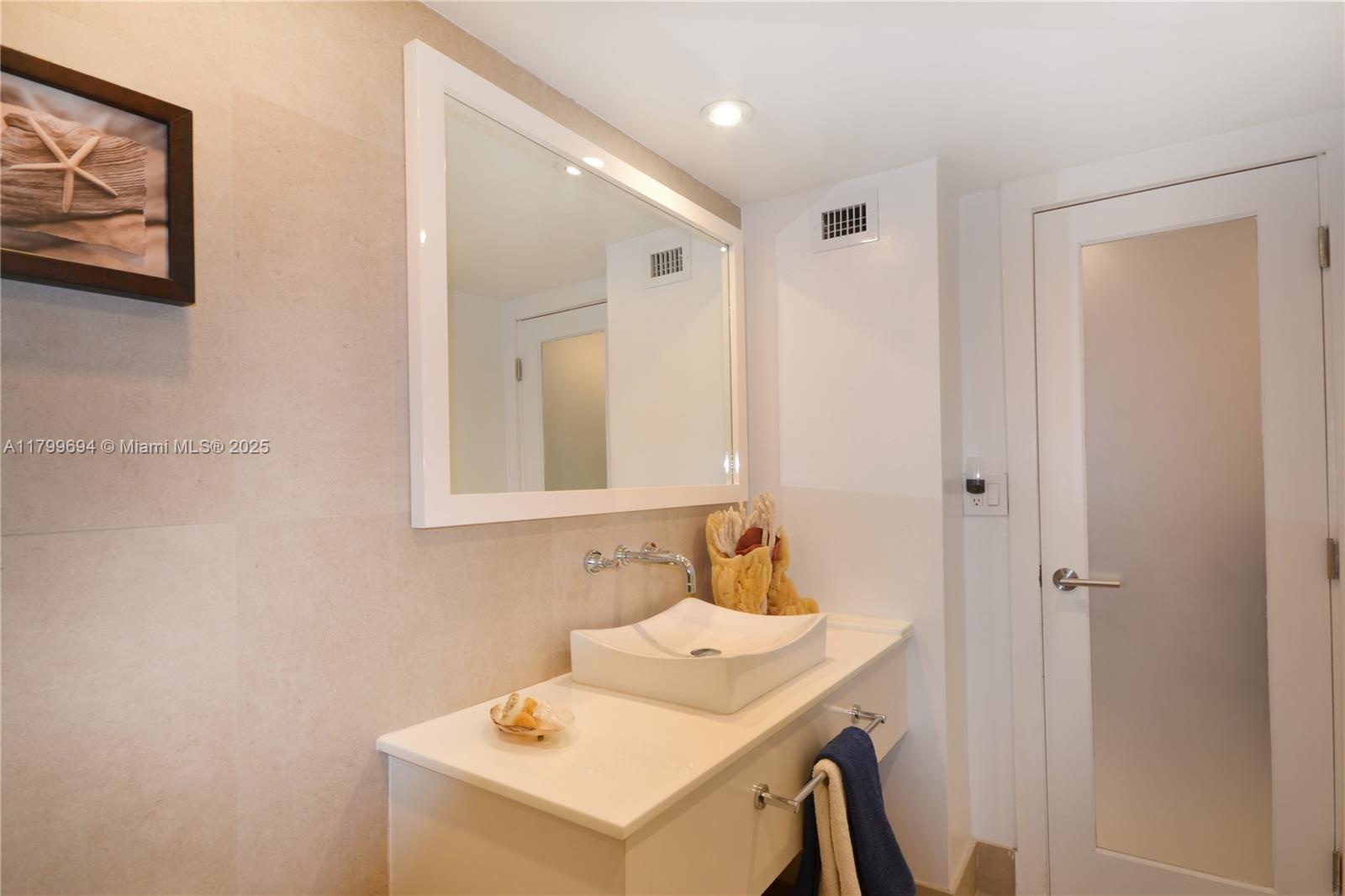 1121 Crandon Boulevard, Unit E307 Key Biscayne, FL 33149 - Photo 11 of 30 a bathroom with a sink a toilet and mirror