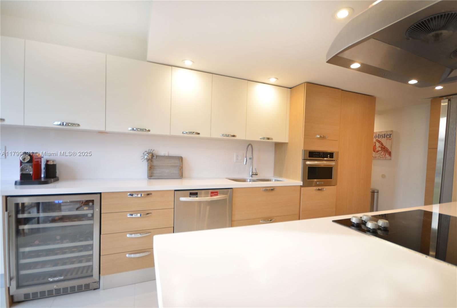 1121 Crandon Boulevard, Unit E307 Key Biscayne, FL 33149 - Photo 4 of 30 a kitchen with kitchen island granite countertop a sink and cabinets