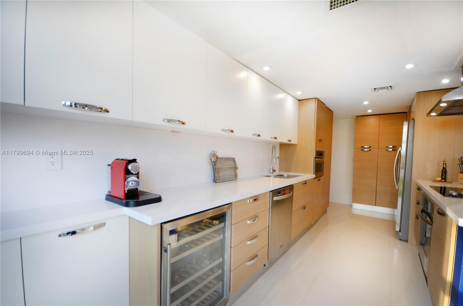 1121 Crandon Boulevard, Unit E307 Key Biscayne, FL 33149 - Photo 5 of 30 a kitchen with cabinets and stainless steel appliances