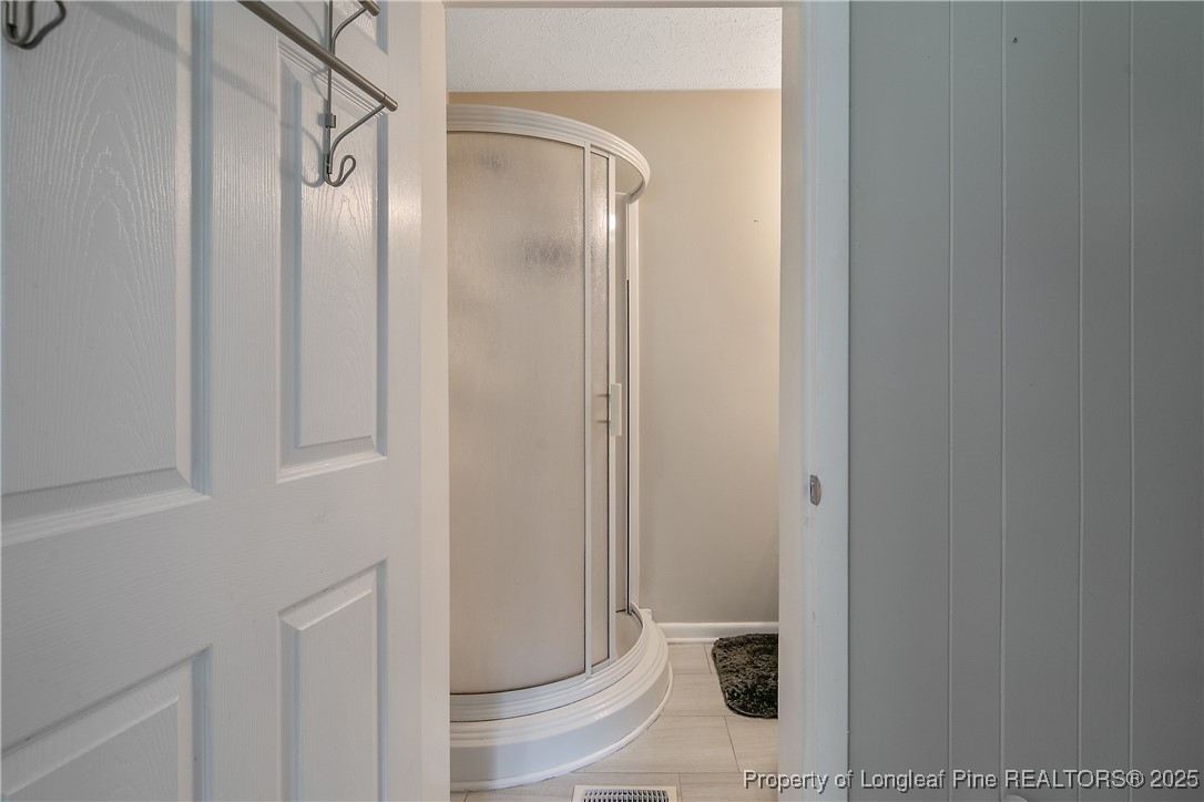 4914 Pinewood Drive Hope Mills, NC 28348 - Photo 15 of 36 a bathroom with a glass shower door