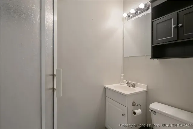 an empty room with wooden floor a ceiling fan and windows