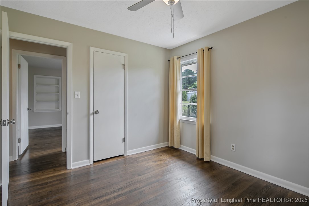 4914 Pinewood Drive Hope Mills, NC 28348 - Photo 22 of 36 an empty room with wooden floor a ceiling fan and windows