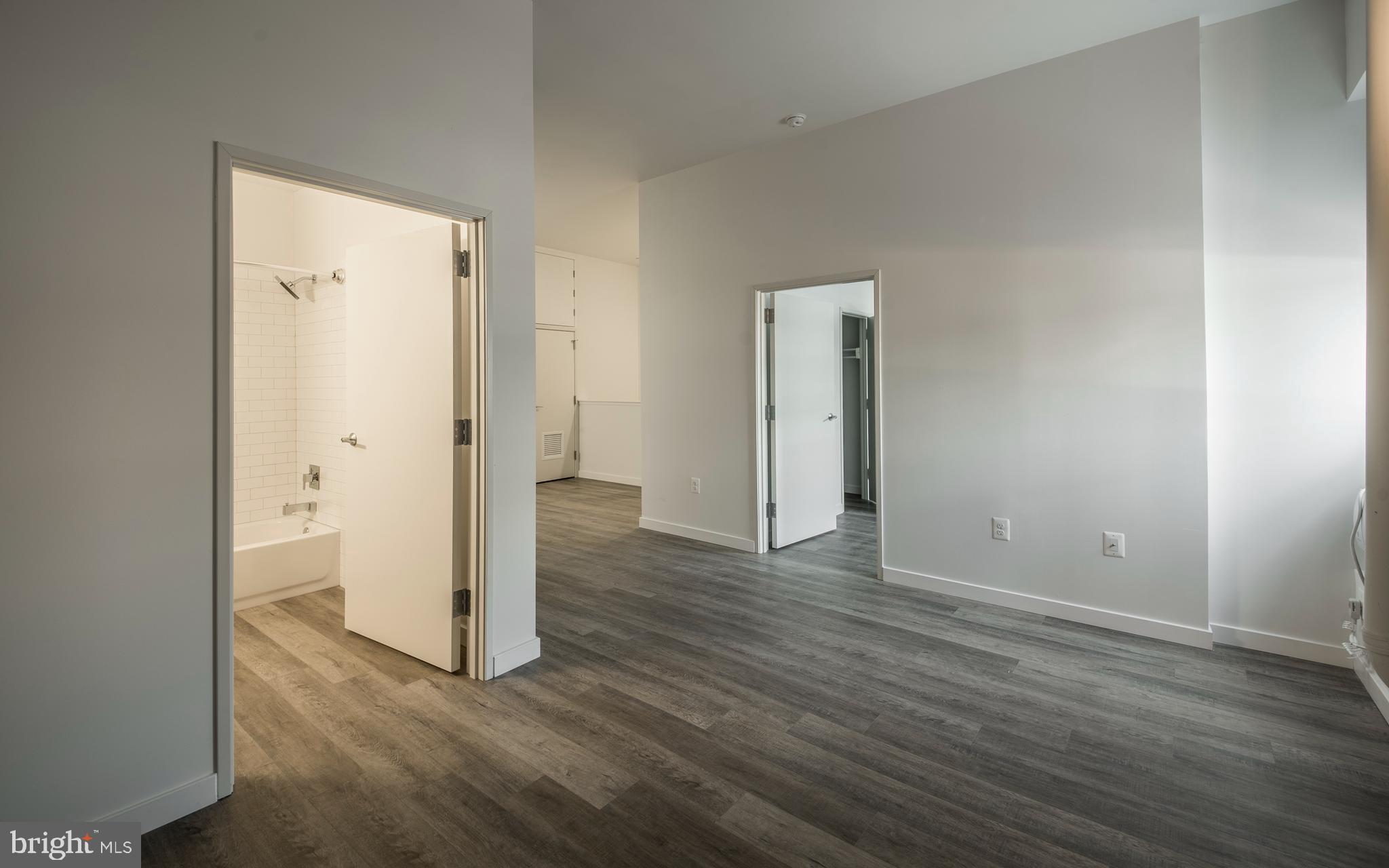 1201 Jackson Street, Unit 516 Philadelphia, PA 19148 - Photo 31 of 42 an empty room with wooden floor and entrance