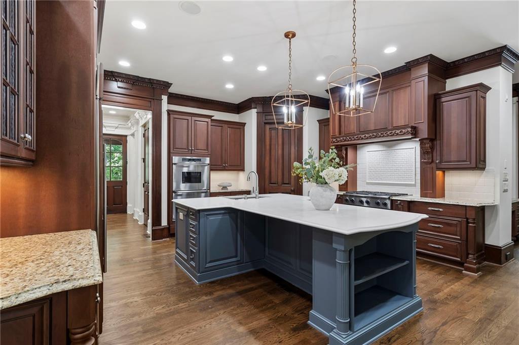 989 Middle Fork Trail Suwanee, GA 30024 - Photo 22 of 76 a kitchen with kitchen island granite countertop a sink stainless steel appliances and cabinets