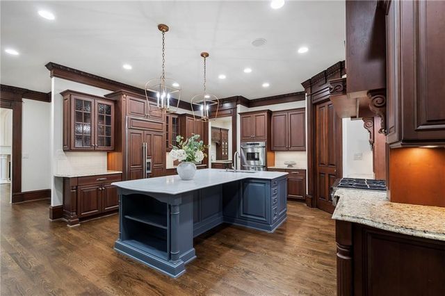a view of an empty room with wooden floor fan and windows