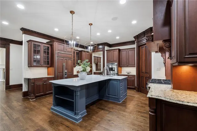 a view of an empty room with wooden floor fan and windows