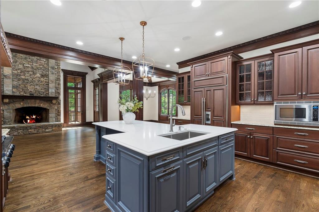 989 Middle Fork Trail Suwanee, GA 30024 - Photo 24 of 76 a kitchen with kitchen island granite countertop a stove and a wooden floors