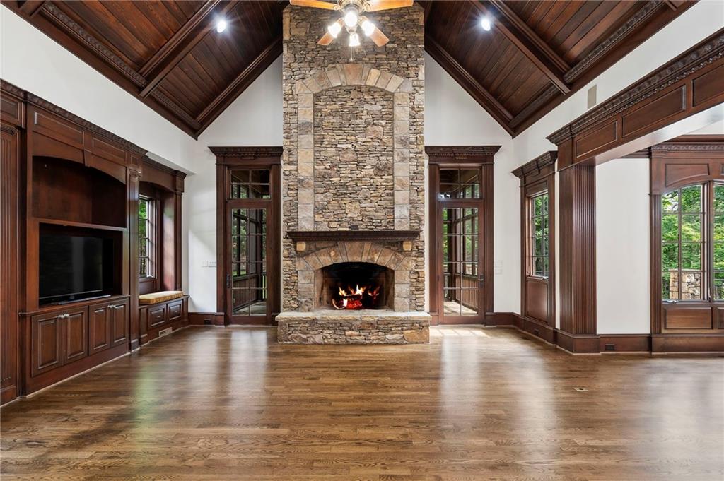 989 Middle Fork Trail Suwanee, GA 30024 - Photo 26 of 76 a living room with a fireplace a flat screen tv and a fireplace