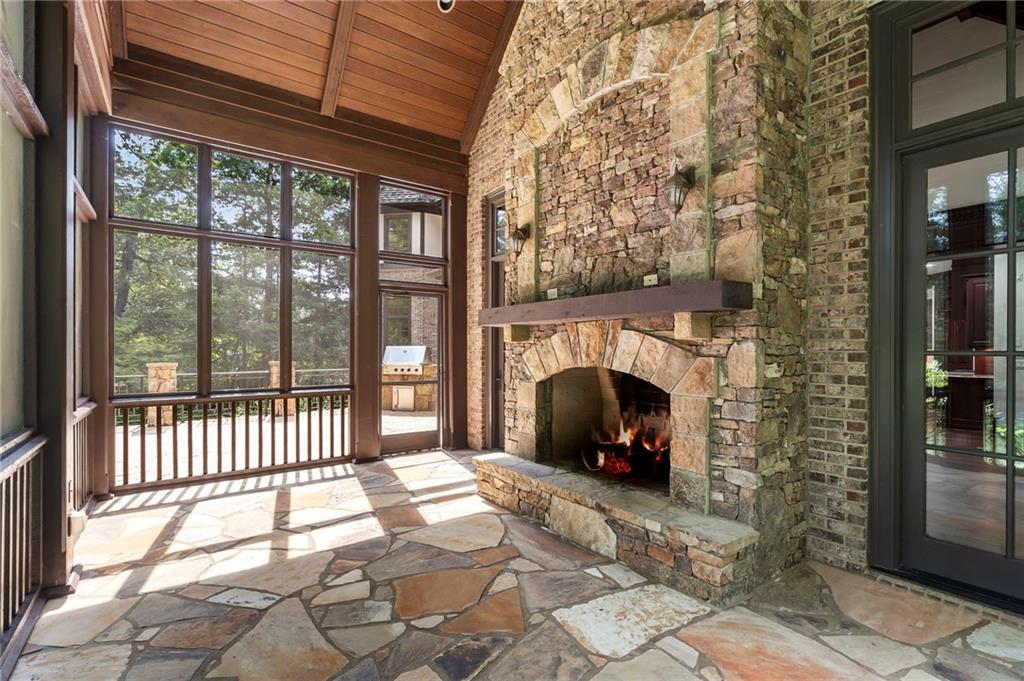 989 Middle Fork Trail Suwanee, GA 30024 - Photo 30 of 76 a view of a porch with a floor to ceiling window and fire pit
