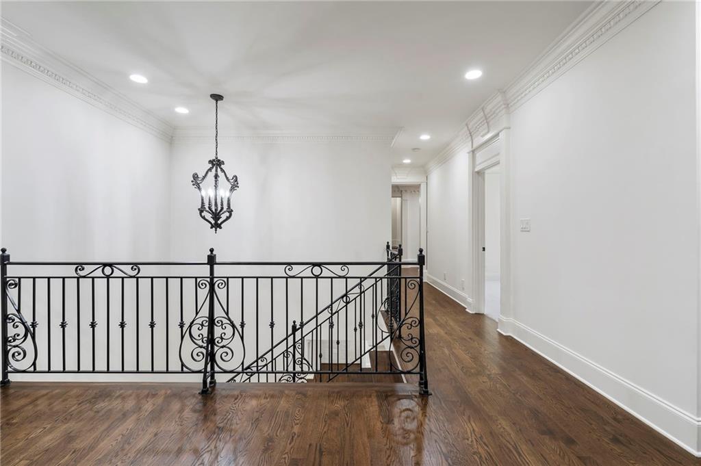 989 Middle Fork Trail Suwanee, GA 30024 - Photo 49 of 76 a view of hallway with wooden floor and pendant lights