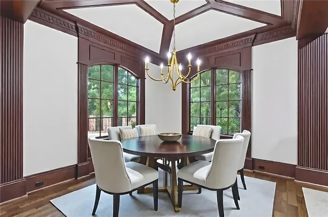 a view of an empty room with wooden floor closet and a window