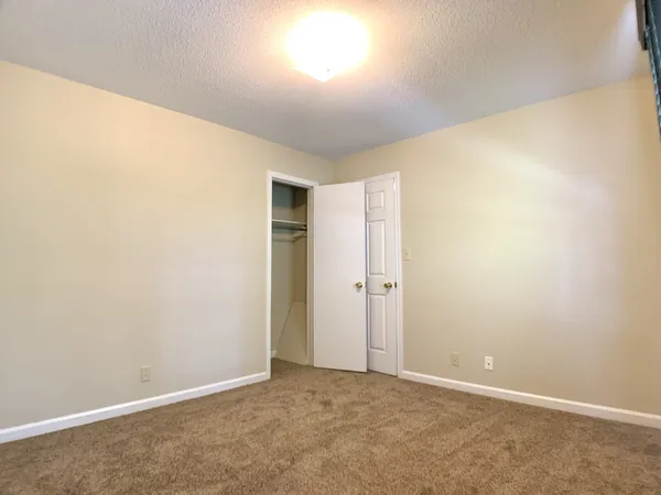 an empty room with fan and windows