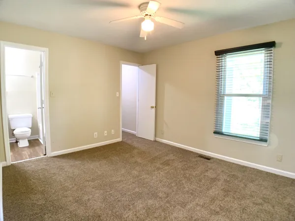 an empty room with closet and windows