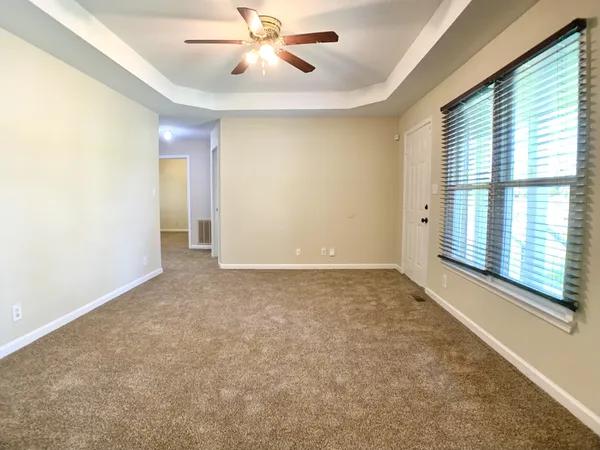 an empty room with windows and fan