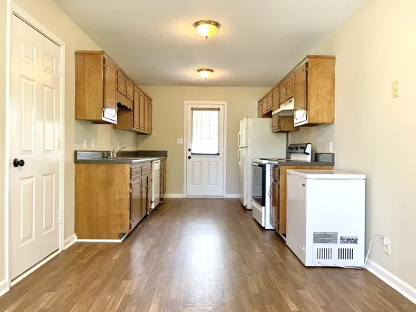 a kitchen with cabinets and wooden floor