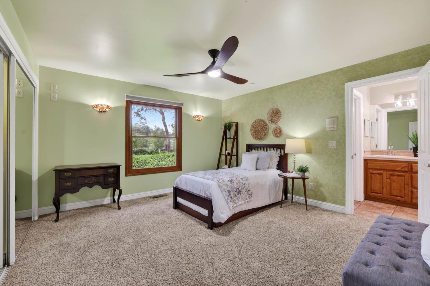 7021 Horseshoe Bar Road Loomis, CA 95650 - Photo 26 of 77 a spacious bedroom with a bed and a chandelier