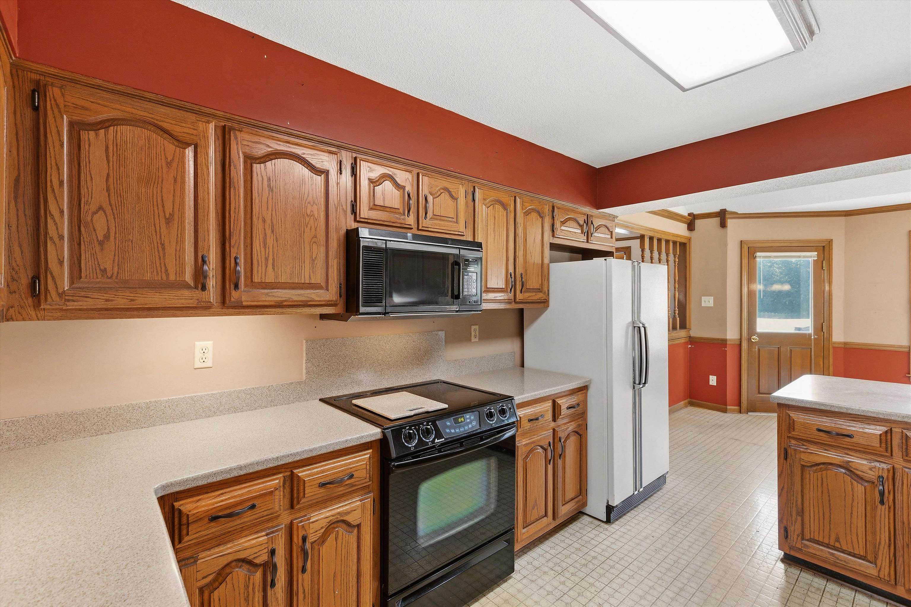 8751 Baylor Road Bartlett, TN 38002 - Photo 13 of 40 24' x 13' Kitchen features 29 oak cabinets plus two pantry cabinets, Corian countertops, refrigerator, KitchenAid dishwasher, trash compactor, range and built-in microwave.