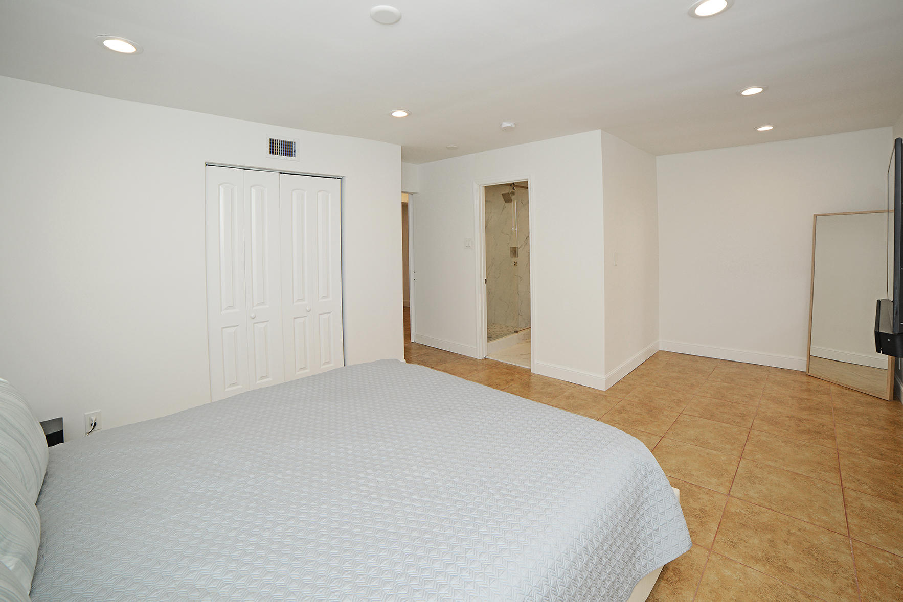 200 Southwest 2nd Street Boca Raton, FL 33432 - Photo 13 of 26 a bedroom with a bed and a large mirror