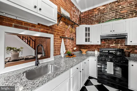 a kitchen with stainless steel appliances granite countertop a sink stove and cabinets