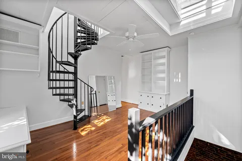 a view of an entryway wooden floor and chandelier