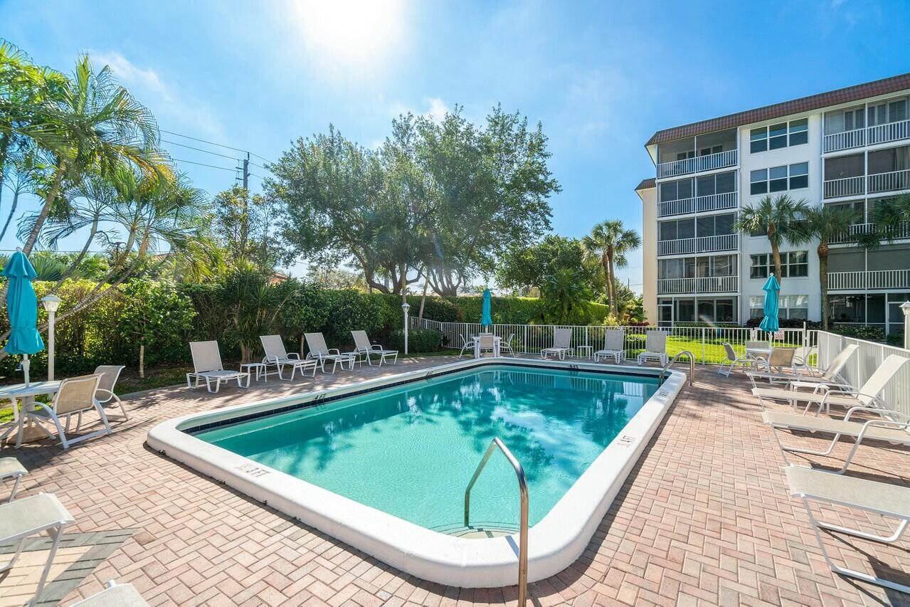 2525 Florida Boulevard, Unit 127 Delray Beach, FL 33483 - Photo 49 of 62 a view of a swimming pool with a lounge chair
